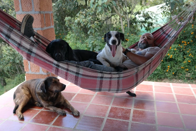 Wilo acostado en una hamaca con Papayita y Tomasa y en el suelo Nutello